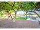 Scenic backyard featuring mature trees, lush lawn, a pool, waterfront views, and a covered patio at 2552 S Playa --, Mesa, AZ 85202
