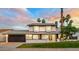 Well-lit two-story home at dusk with a manicured lawn, brick accents, and a spacious two-car garage at 2552 S Playa --, Mesa, AZ 85202