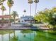 Back of home overlooking waterfront, with lush greenery, swimming pool, dock, and clear blue skies at 2552 S Playa --, Mesa, AZ 85202