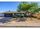 Charming home exterior with a dark garage door, colorful landscaping, and curb appeal at 2608 W Aster Dr, Phoenix, AZ 85029