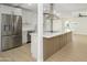 Kitchen island with stainless fridge and white cabinets at 2608 W Aster Dr, Phoenix, AZ 85029
