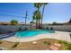 Backyard pool area featuring desert landscaping, a concrete patio, and tall palm trees at 2608 W Aster Dr, Phoenix, AZ 85029