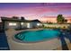 Backyard pool at dusk with beautiful sky and green grass at 2608 W Aster Dr, Phoenix, AZ 85029