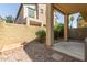 View of the gravel backyard featuring a covered patio, brick wall, and small shrubs at 2727 N Price Rd # 32, Chandler, AZ 85224