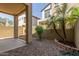 View of the gravel backyard featuring a covered patio, brick wall, and small shrubs at 2727 N Price Rd # 32, Chandler, AZ 85224
