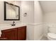 Bathroom featuring dark wood vanity with sink, toilet, and wall paneling at 2727 N Price Rd # 32, Chandler, AZ 85224