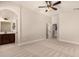 Spacious bedroom with neutral carpet, ceiling fan, and access to the bathroom at 2727 N Price Rd # 32, Chandler, AZ 85224