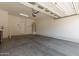 Large, empty garage space with concrete flooring, water heater, and an entrance door at 2727 N Price Rd # 32, Chandler, AZ 85224
