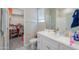 Bright bathroom with a single sink vanity, white cabinets and a view into a walk-in closet at 281 E Shamrock Dr, Chandler, AZ 85286