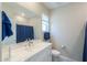 Bathroom featuring a white vanity, large mirror, toilet, and shower with blue accents at 281 E Shamrock Dr, Chandler, AZ 85286