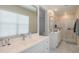Bright bathroom with a double sink vanity, white cabinets and a frameless glass shower at 281 E Shamrock Dr, Chandler, AZ 85286