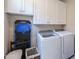 Well-organized laundry room with white cabinets, modern washer and dryer, and storage solutions at 281 E Shamrock Dr, Chandler, AZ 85286