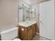 Bright bathroom featuring a white toilet and a wooden vanity with mirror and lighting at 2986 N Oregon St # 7, Chandler, AZ 85225