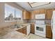 Functional kitchen features white appliances and a sink overlooking the window at 2986 N Oregon St # 7, Chandler, AZ 85225
