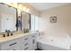 Bathroom boasts a large vanity with dual sinks, modern fixtures, and a soaking tub at 3021 E Harmony Cir, Mesa, AZ 85204