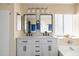 Bathroom vanity has dual sinks, modern fixtures, decorative mirrors, and a soaking tub at 3021 E Harmony Cir, Mesa, AZ 85204