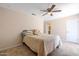 Comfortable bedroom features neutral walls, carpet, ceiling fan and easy access to bathroom at 3021 E Harmony Cir, Mesa, AZ 85204