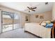 Cozy bedroom with sliding glass door to private patio, neutral walls, and ceiling fan at 3021 E Harmony Cir, Mesa, AZ 85204