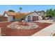 Charming single-story home featuring a well-manicured yard with unique rock landscaping and a two car garage at 3021 E Harmony Cir, Mesa, AZ 85204