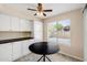 Bright kitchen with white cabinets, black countertops, tile flooring, and a large window, perfect for casual dining at 3021 E Harmony Cir, Mesa, AZ 85204