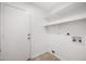 This is a simple laundry room with shelving and hookups at 3021 E Harmony Cir, Mesa, AZ 85204