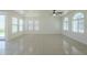 Expansive living room featuring tile flooring, large windows, contemporary lighting, and sliding glass door access at 3451 S Wren Dr, Gilbert, AZ 85297