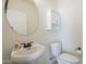 Well-lit powder room with a pedestal sink, round mirror, and updated fixtures at 3451 S Wren Dr, Gilbert, AZ 85297