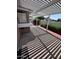 Back patio with a white pergola, concrete pad, and red brick border and landscaping at 3510 E Hampton Ave # 133, Mesa, AZ 85204