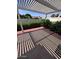Covered back patio with nice landscaping and a red brick border around the perimeter of the concrete pad at 3510 E Hampton Ave # 133, Mesa, AZ 85204