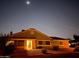 Exterior view of a single story home at dusk with desert landscaping, a welcoming porch light, and clear starry sky at 3510 E Hampton Ave # 133, Mesa, AZ 85204