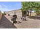 Backyard featuring gravel, mature trees, and comfortable Adirondack chairs perfect for outdoor relaxation at 37103 N El Morro Trl, San Tan Valley, AZ 85140