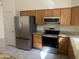 Modern kitchen with stainless steel appliances, granite countertops, and light wood cabinets at 3853 W Calle Lejos --, Glendale, AZ 85310