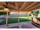 Covered patio featuring lush green backyard, a built-in hot tub, and brick flooring at 3853 W Calle Lejos --, Glendale, AZ 85310