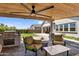 Covered outdoor patio featuring a built-in grill, comfortable seating, and views of the landscaped yard at 3915 N Shannon Cir, Mesa, AZ 85215