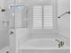 Close up of tub with marble surround and bronze fixtures near glass shower at 3915 N Shannon Cir, Mesa, AZ 85215