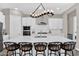 Modern kitchen with a large island, stainless steel appliances, white cabinetry, and stylish lighting at 3915 N Shannon Cir, Mesa, AZ 85215