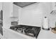 Close-up of stainless steel stove top with white subway tile backsplash and white quartz countertops at 3915 N Shannon Cir, Mesa, AZ 85215