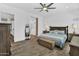 Bright main bedroom with wood-look tile floors, a ceiling fan, and a view into the main bathroom at 3915 N Shannon Cir, Mesa, AZ 85215