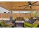 Inviting covered patio with stylish seating, ceiling fan, and a peaceful outdoor setting at 3915 N Shannon Cir, Mesa, AZ 85215