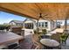 Covered patio featuring an outdoor kitchen, comfortable seating, and a relaxing space for entertaining at 3915 N Shannon Cir, Mesa, AZ 85215