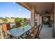 Covered patio with table and chairs offers relaxing outdoor dining area overlooking the pool and landscaped backyard at 4029 N 160Th Dr, Goodyear, AZ 85395
