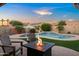 Inviting backyard with a pool, waterfall feature, a fire pit, and an umbrella table perfect for outdoor gatherings at 4029 N 160Th Dr, Goodyear, AZ 85395