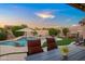 Inviting backyard pool area with mature landscaping, in-pool seating, and a hot tub at 4029 N 160Th Dr, Goodyear, AZ 85395