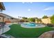 Well maintained backyard with turf surrounding the pool and various areas for relaxing and lounging at 4029 N 160Th Dr, Goodyear, AZ 85395