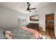 Bright bedroom featuring a TV, ceiling fan, wood floors and shuttered windows at 4029 N 160Th Dr, Goodyear, AZ 85395