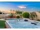 Relaxing hot tub with a view of the lush backyard and pool at 4029 N 160Th Dr, Goodyear, AZ 85395