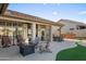 Inviting covered patio with outdoor seating, fire pit, built-in grill, and manicured artificial grass at 4029 N 160Th Dr, Goodyear, AZ 85395