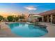 Inviting backyard oasis featuring a sparkling pool, in-pool seating, and a relaxing hot tub at 4029 N 160Th Dr, Goodyear, AZ 85395