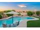 A picturesque pool featuring blue tile accents, in-pool seating, and lush landscaping at 4029 N 160Th Dr, Goodyear, AZ 85395