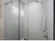 Modern shower with glass doors and white textured tile walls provides an open and airy space at 4029 N 160Th Dr, Goodyear, AZ 85395